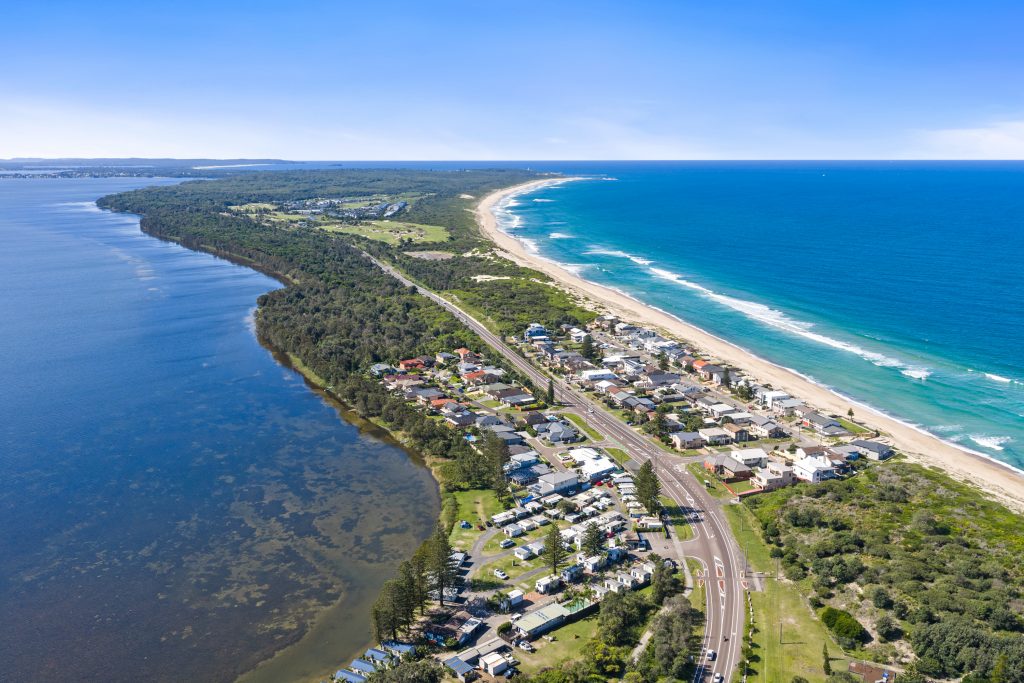 Aerial view of The Entrance North NSW, with Tuggerah Lake on one side and the ocean beach on the other