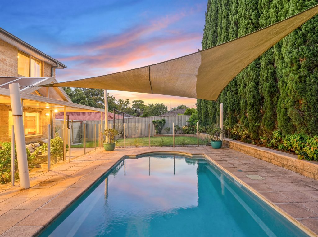 Backyard swimming pool with shade sail at an Erina family home
