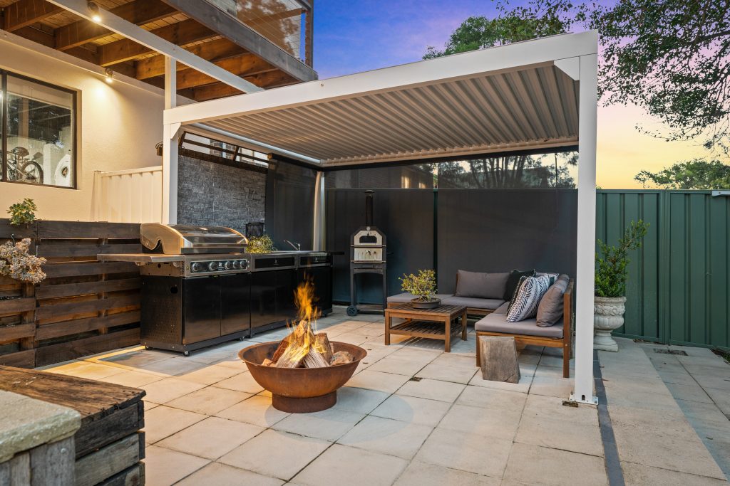 Outdoor entertaining area with fire pit and barbecue at a Wyoming NSW home
